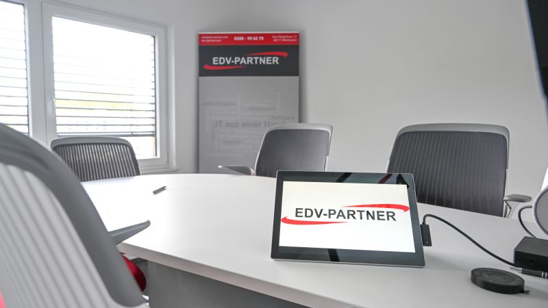 Zu sehen ist ein Foto vom Beratungsraum der EDV-PARTNER GmbH. Ein Surface ist an einem großen Monitor angeschlossen und das Logo der EDV-PARTNER GmbH ist geöffnet.